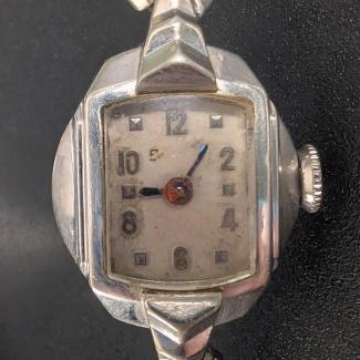 Ladies watch with a small, discolored face behind scratched crystal