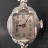 Ladies watch with a small, discolored face behind scratched crystal