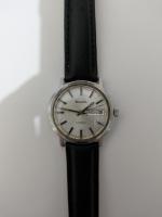 Day-date complication on the right side, automatic on the bottom; case is oblong, strap was originally a steel bracelet but replaced with a 3rd party leather strap