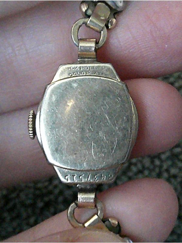 person holding watch showing the back of the case