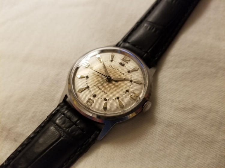 Angled view of watch better showing texture of dial