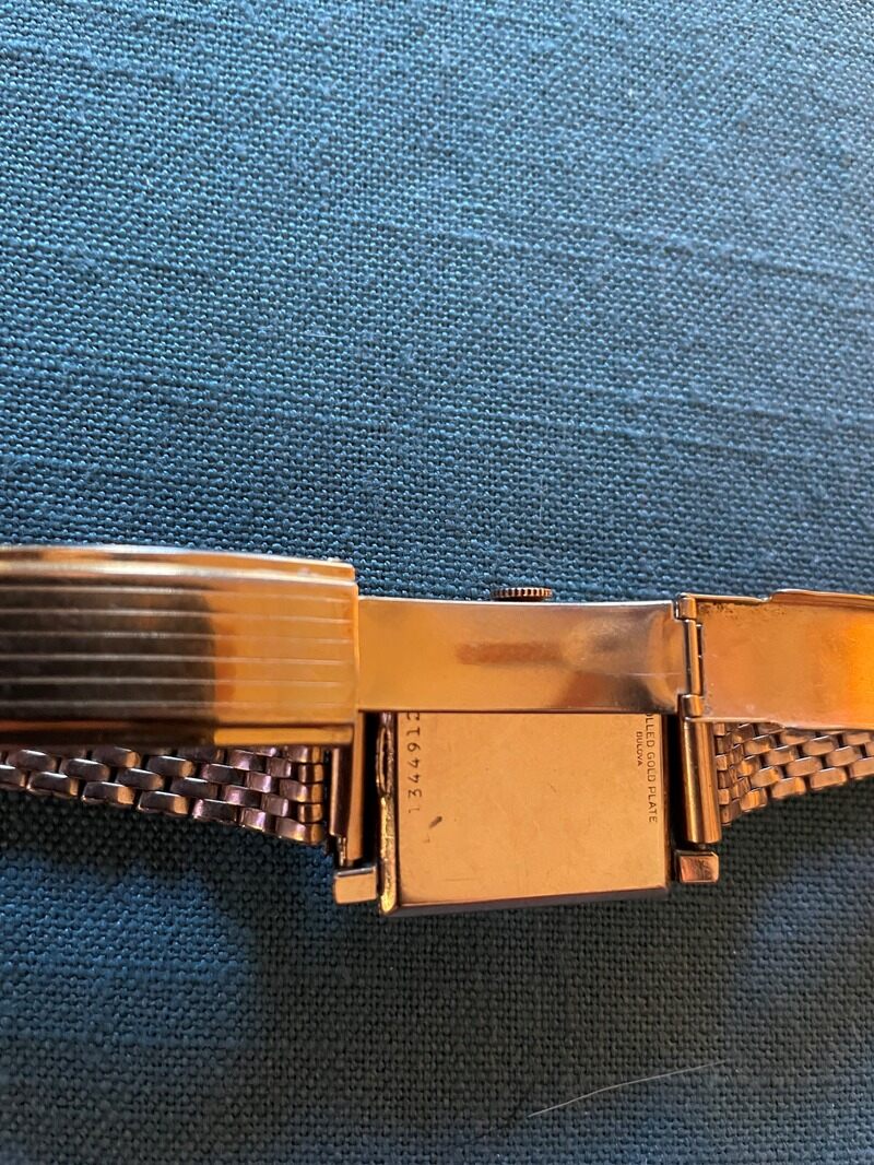 Back of rectangular watch with two-tone gold face with serial number