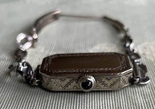 edge of watch with floral pattern, chipped sapphire crown