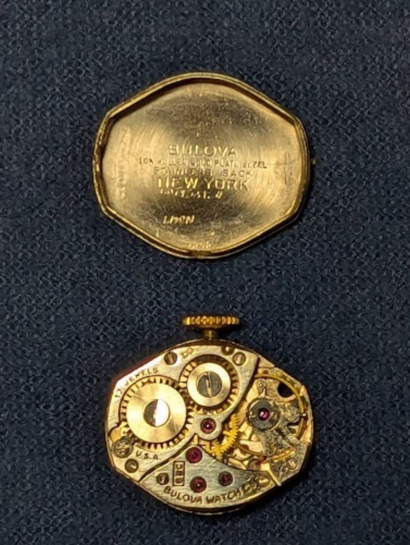 A picture of the bulova movement and the inside of the back.